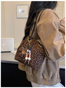 Detailed view of a stylish retro brushed leopard print bucket bag featuring a chic flower charm.