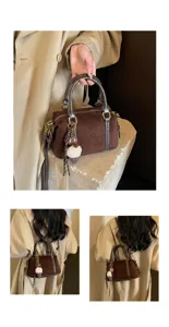 Retro brown suede Boston bag for women, stylish commuter shoulder and crossbody bag with charm.