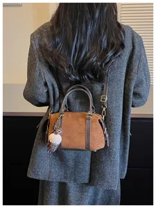 Retro brown suede Boston bag for women, stylish commuter shoulder crossbody handbag with charm.