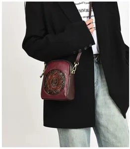 Vintage embossed leather crossbody bag featuring intricate floral carving and gold hardware.