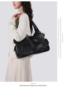 Black leather shoulder bag detail showing multi zipper pockets and durable craftsmanship.