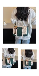 Dettaglio di borsa da viaggio elegante e color-block con tracolla multifunzionale e ciondolo floreale.