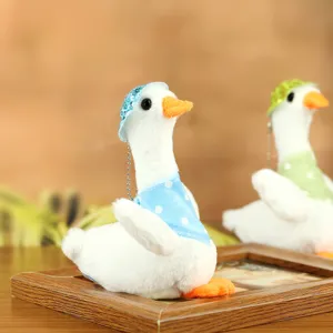 Cute plush duck toy detail showing soft white fabric, adorable blue polka-dot hat and bib.