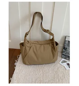 Casual khaki nylon shoulder bag detail, showcasing large capacity, adjustable strap and multi-pockets.