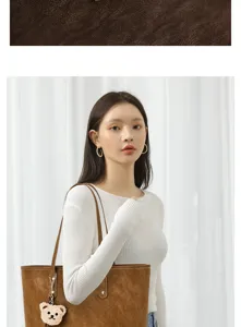 Vue détaillée d'un sac cabas marron rétro avec charmant pendentif ours pour femmes.