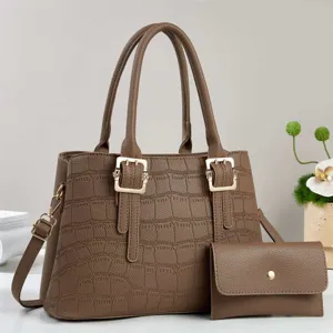 Vista detallada de un elegante bolso de mano marrón con textura de cocodrilo para mujer.