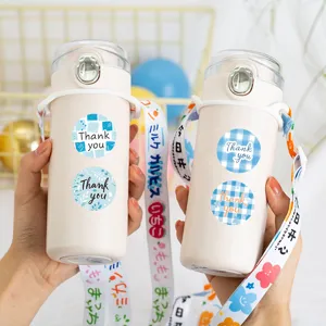Close up detail view of portable water bottle decorated with cute blue thank you round stickers.