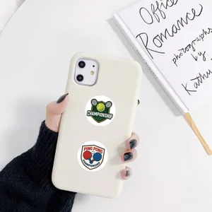 Detailed view of white smartphone case decorated with tennis and ping pong round stickers.