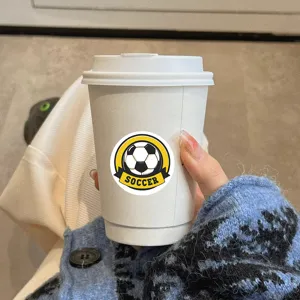 Round soccer sports sticker with clear football graphic and bold yellow lettering design.