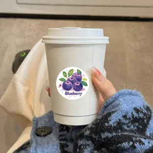 Closeup of cute cartoon blueberry sticker on cup, perfect for journaling and kids reward decor.