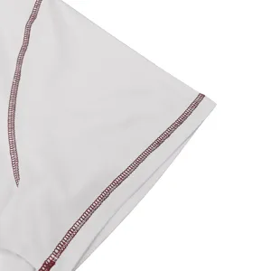 Close-up detail shot of white fabric featuring neat contrast maroon flatlock stitching.