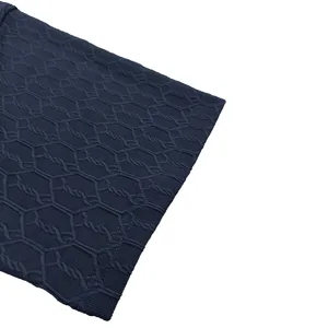 Close-up detail of dark blue textured knit fabric showcasing geometric pattern and quality weave.