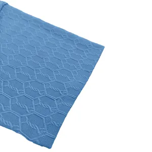 Close-up detail of blue men's polo shirt sleeve with geometric knitted mesh texture.
