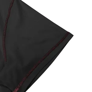 Men's casual t-shirt detail showing black fabric with red stitching and fine craftsmanship.