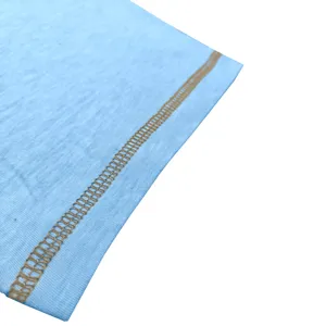 Detailed view of light blue t-shirt fabric with contrast brown stitching craftsmanship.