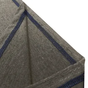 Close-up detail of the garment fabric texture and neat dark blue overlock stitching finish.