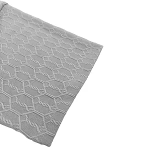 Close-up view of the grey fabric texture with unique hexagonal knit pattern details.