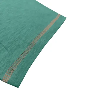Close-up detail of green t-shirt fabric featuring neat contrast stitching craftsmanship.