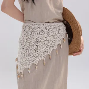 Detailed shot of French pastoral crochet cotton triangular hip scarf with seashell fringe.