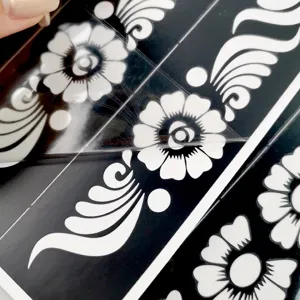 Gros plan détaillé du pochoir de tatouage au henné floral noir et blanc avec motif ajouré.