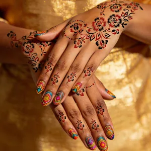 Nahaufnahme von traditionellen Henna Blumen Tattoos und farbenfrohen Nagelkunst-Aufklebern.