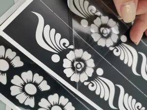 Détail de pochoir de tatouage au henné avec motif floral et film de protection transparent.