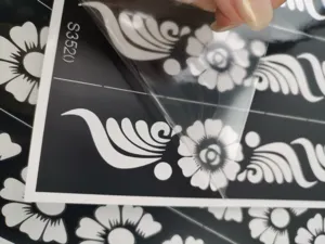 Vue détaillée du pochoir de tatouage au henné avec motif floral, montrant le retrait du film.