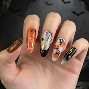 Gros plan sur les art des ongles d'Halloween avec citrouilles, araignées et motifs de toile dorés.