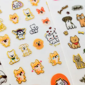 Close up detail of cute cartoon animal nail stickers with gold foil outline, cat and dog design.