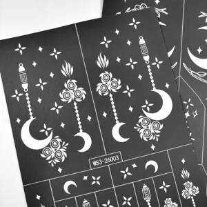 Detail view of black henna tattoo stencil sticker sheet featuring moon, rose, and lantern patterns.