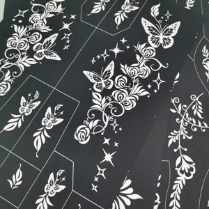 Gros plan détaillé de pochoirs de tatouage creux avec des motifs de papillons et roses.
