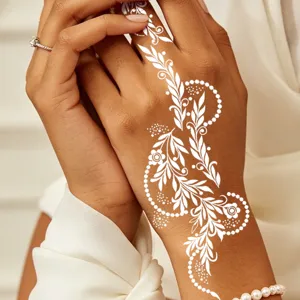 Detailed close-up of white henna lace tattoo sticker on hand, elegant party body art design.