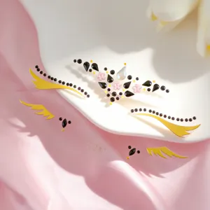 Primer plano detallado de diamantes de imitación brillantes con pestañas doradas y flores rosas.