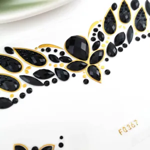 Primer plano detallado de pegatina de diamantes de imitación negros y dorados para la cara.