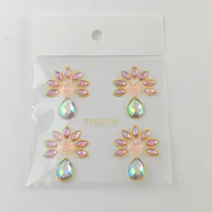Primer plano detalle de pegatinas de estrás para la cara con flores y gotas.