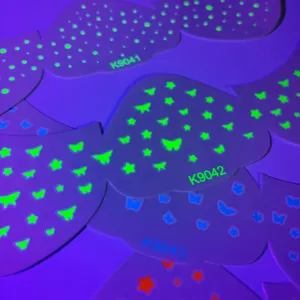 Fluoreszierende Gesichtsaufkleber im Detail mit leuchtenden Sternen und Schmetterlingsmustern.