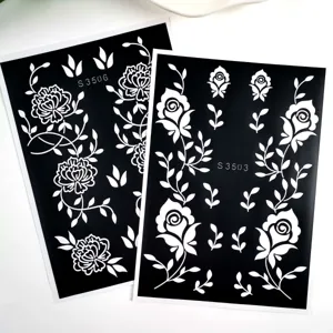 Detailed view of black and white floral henna tattoo stencils with clear hollow cutout patterns.