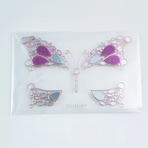 Close-up detail of pink butterfly face gems rhinestone stickers for festival makeup party decor.