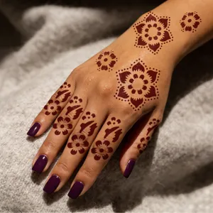 Close-up detail of intricate mandala and floral henna tattoo stencil sticker on hand model.