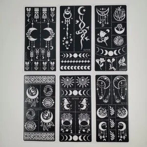 Detailed view of reusable hollow tattoo stencils featuring moon and flower patterns for art.