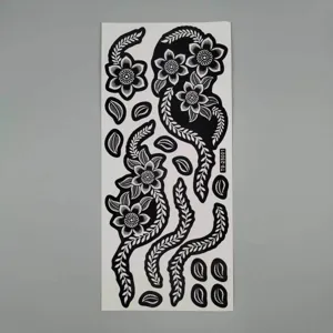 Detailed view of black and white floral tattoo sticker sheet, intricate lace vine stencils for body art.