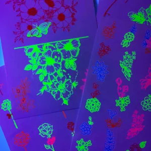 Vue détaillée d'autocollants de tatouage temporaire fluorescents lumineux avec motifs floraux.