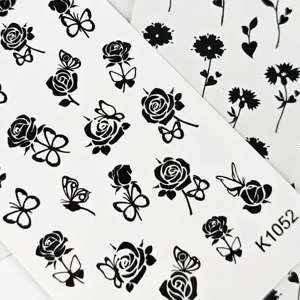 Close-up detail van vellen met zwarte rozen en vlinders tijdelijke tattoos of nagelstickers.