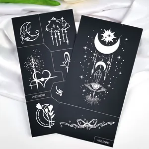Tatouages temporaires blancs détaillés avec des motifs de lune et d'étoiles.