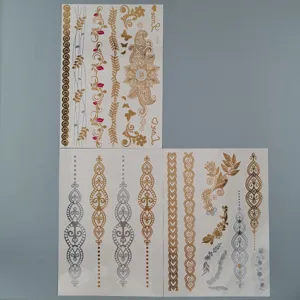 Detailed view of metallic gold and silver henna temporary tattoo sticker sheets with intricate patterns.
