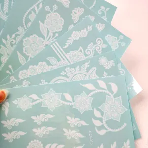 Close-up detail view of elegant white lace floral henna temporary tattoo sticker sheets.