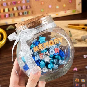 Klares Glas Erinnerungsglas mit Korkdeckel und Silberband, gefüllt mit Origami Sternen.
