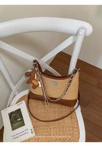 Woven straw shoulder bag with leather trim, chain strap and cute dog charm for women.