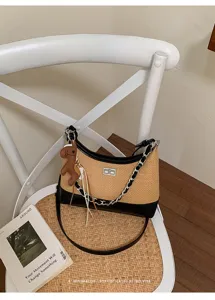 Detailed view of the woven shoulder bag with chic metal chain and vintage lock design.