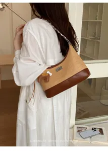 Detailed view of stylish woven hobo shoulder bag with chain strap and cute pendant.